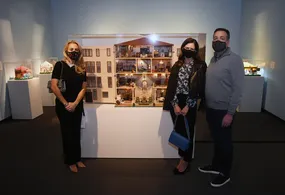 People standing in front of the Fisher dollhouse