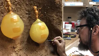 Photo of man painting a diorama of honeypot ants for a museum exhibition.