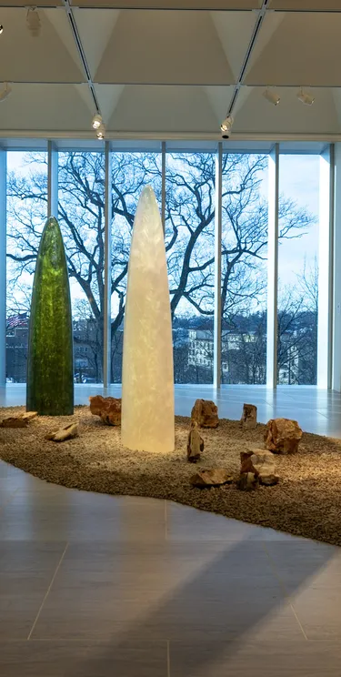 Standing sculptures shaped like colorful, translucent rockets and amorphous wall pieces that refract light.